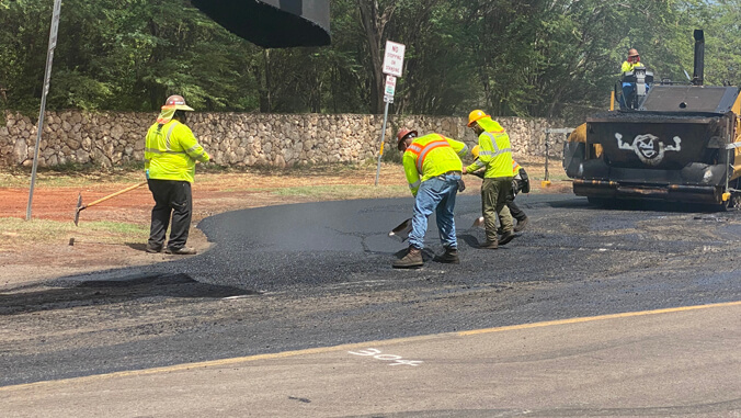 people working on paving a road
