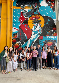 Group standing in front of large street mural