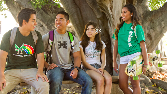 four people standing or sitting while talking to each other