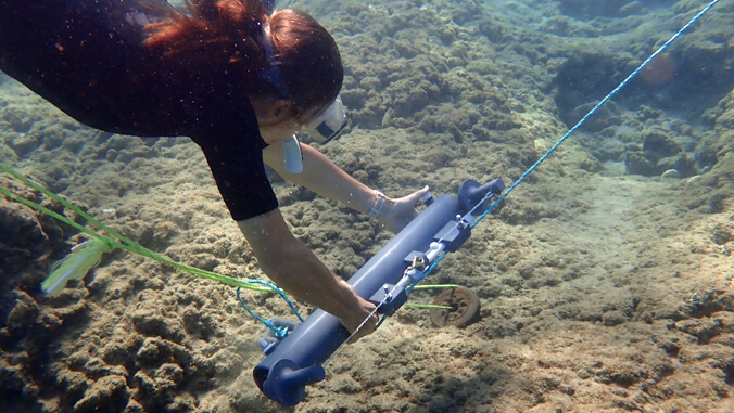 girl collecting water samples on coral reef