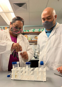 Two people in lab looking at test tubes