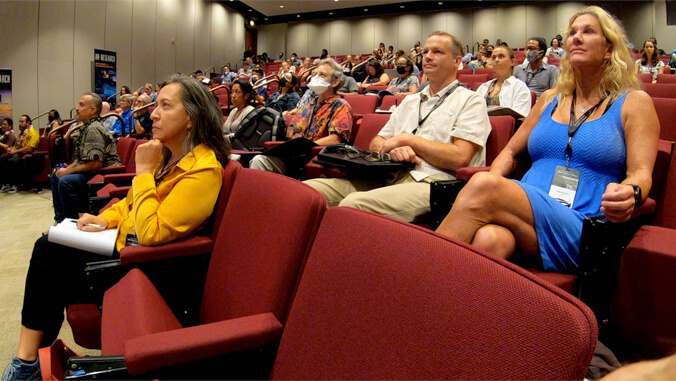 people sitting in chairs in an auditorium