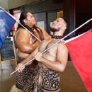 Two students proudly holding flags of Samoa