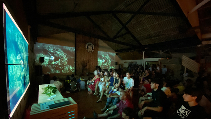 People sitting while watching large screens