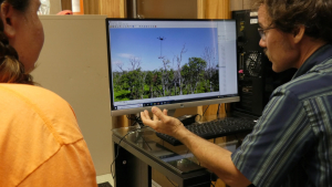 Two people looking at a computer monitor