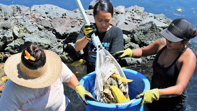 People putting debris into a bucket