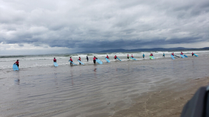 A line of surfers headed out into the ocean