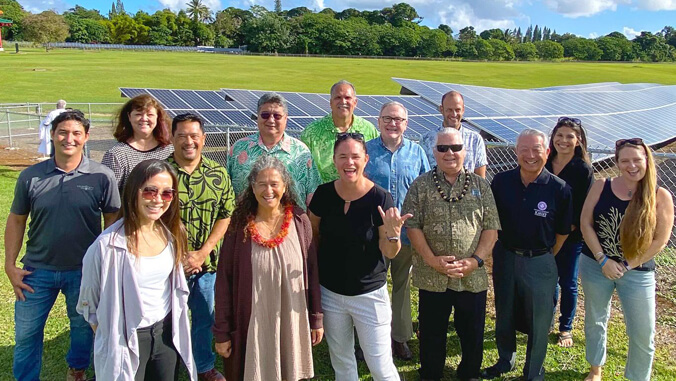group of people standing in front of PV panels