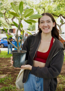 person smiling with a plant
