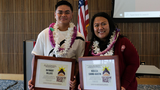 Two people holding award plaques