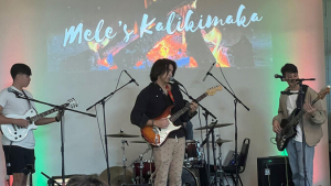 Three performers with guitars on stage