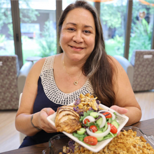 Hardy-Kahaleoumi smiling and holding a plate of food