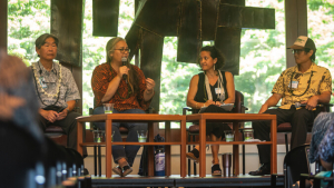 Four people sitting on stage