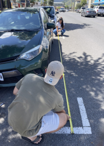 people kneeling with a measuring tape