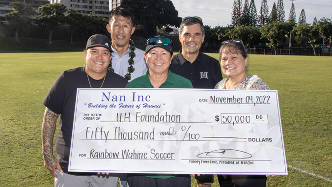 five people holding a big check