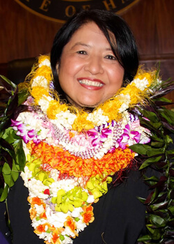 Woman with many lei smiling