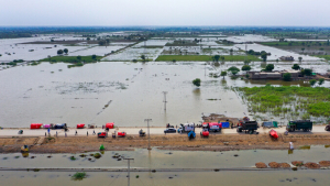 Aerial view of flooded fields and a road with emergency vehicles
