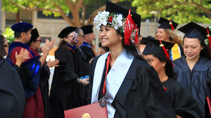 U H graduates with lei