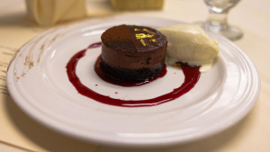 Chocolate cake with vanilla ice cream and a circle of sauce