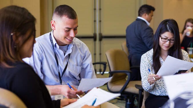 people smiling while looking at a piece of paper