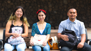 Three students sitting on a bench
