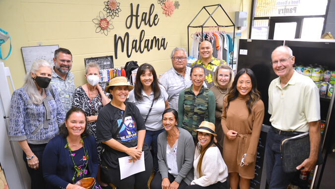 group of people in front of Hale Malama sign