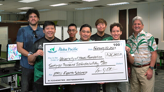 people smiling next to a large check