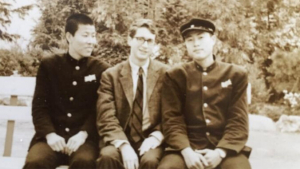 Three people sitting on a bench and smiling