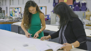 Fashion student and teacher cutting fabric on a table