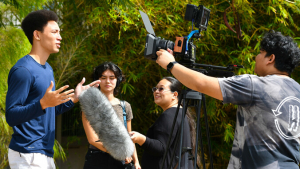 A group of students filming another student
