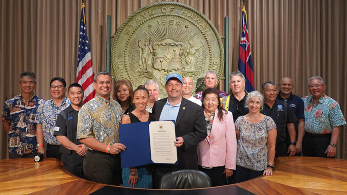 A group of people smiling and holding a proclamation