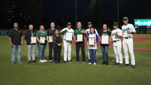 people smiling at the camera holding plaques