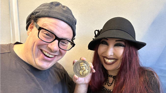 Two people holding a medallion