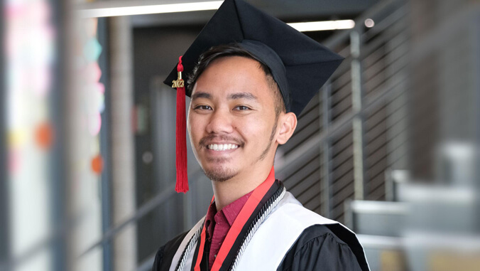 Student smiling in graduation regalia