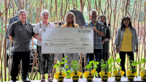 Scholarship recipient and group of people with a large check