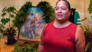 Kanahele-Mossman standing in front of a portrait of Edith Kanakaole