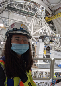 person smiling with a mask inside a telescope