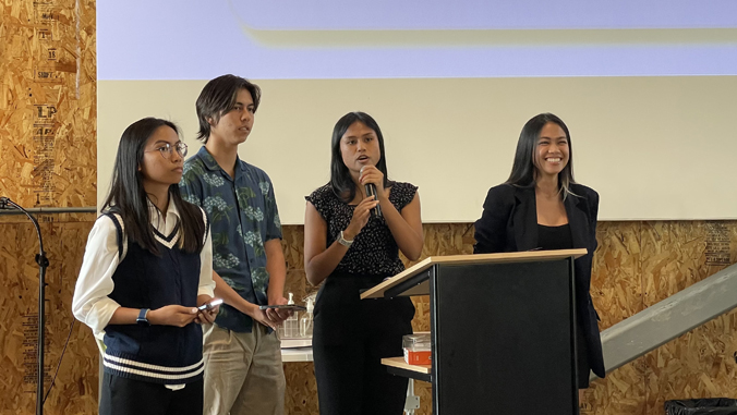 four people on a stage presenting