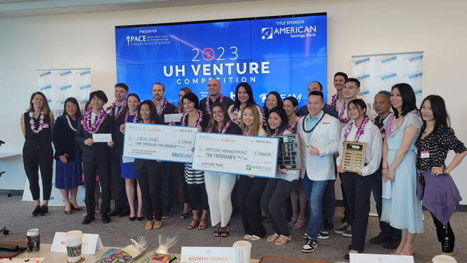 dozens of people standing and smiling with large checks