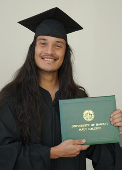 Graduate in cap and gown holding a diploma