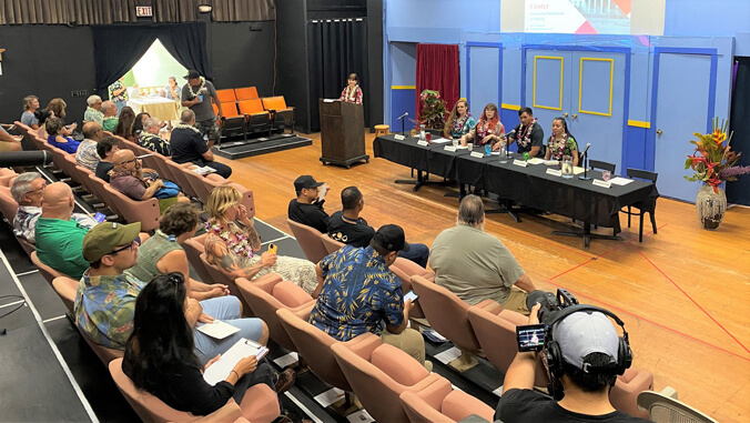 Four seated students presenting to an audience