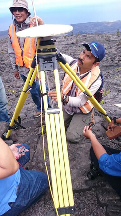 people working on antenna in a lava field