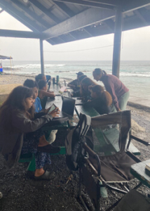 people near the beach working on computers