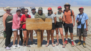 Students taking picture with a sign 