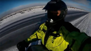 person on a motorcycle driving through a road with ice