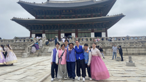 people smiling in front of a large temple