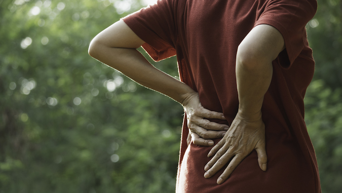 person placing hands on back