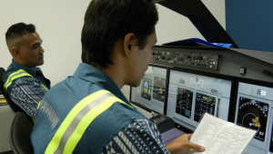 Two people sitting in a training control console