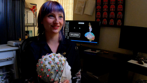 person smiling holding up a brain model