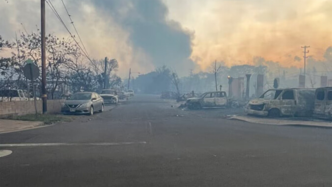 Burned out street with smoke in the background